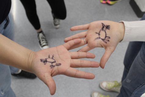 Students draw turkeys on their hands to share festivity.